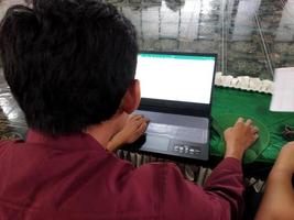 kasongan, indonésia, 2022-homem trabalhando na frente de um laptop foto