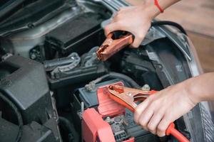 mulher irreconhecível consertando um carro. foto