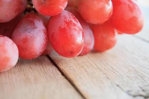 uvas vermelhas em fundo de madeira foto