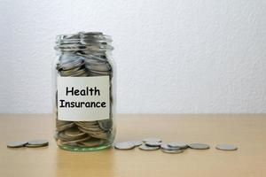 economia de dinheiro para seguro de saúde na garrafa de vidro foto