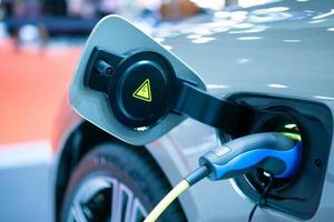 close-up plug power veículo elétrico ev carro carregar energia da bateria na estação. conceito de ambiente eco verde. foco seletivo. foto