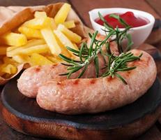 salsichas de frango grelhadas com acompanhamento de batatas fritas foto