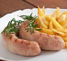 salsichas de frango grelhadas com acompanhamento de batatas fritas foto