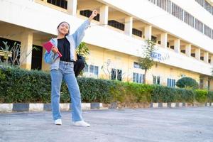 aluna de pé na escola com prédio, garota asiática. foto