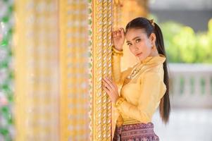 encantadoras mulheres tailandesas em trajes tradicionais tailandeses se preparam para homenagear o buda em um templo tailandês para orar pela tradição songkran na tailândia foto