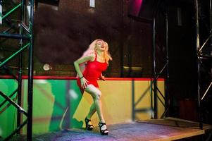 noiva incrível no vestido vermelho dançando no palco à noite em sua despedida de solteira. foto