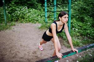 garota esportiva no sportswear exercitando-se em exercícios de barra horizontal em um parque verde e treinamento na natureza. um estilo de vida saudável. foto