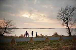 mãe com filhos na margem do lago. foto