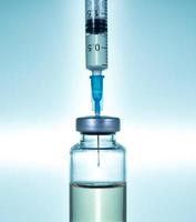 agulha de seringa hipodérmica inserida em uma ampola ou garrafa de vacina foto