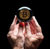 bola de previsão de vidro de cristal segurada pelas mãos do homem prevendo o preço futuro do bitcoin foto