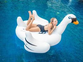 jovem mulher bonita caucasiana está relaxando na piscina inflável. foto