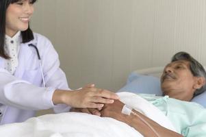 médico segurando a mão do paciente sênior no hospital, cuidados de saúde e conceito médico foto