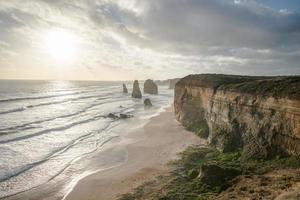 vista de doze apóstolos uma formação rochosa icônica durante o pôr do sol na grande estrada oceânica do estado de vitória da austrália. foto