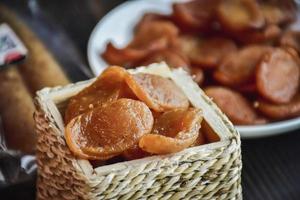 salsicha ou guan chiang e ervas no tabuleiro, servindo bons petiscos de cerveja em um fundo escuro. foto