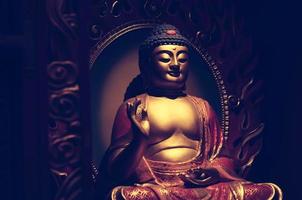 a estátua de buda dourada da ásia, a escultura de arte antiga, o sinal do budismo, budista, deus com fundo de desenvolvimento de cores frias de processo cruzado. a arquitetura asiática. foto