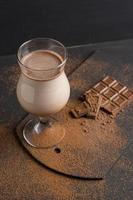 copo de milk-shake de chocolate em cima da mesa foto