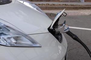 carros inteligentes movidos a eletricidade estão carregando em estações de beira de estrada. foto