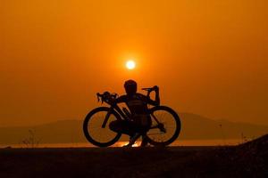 silhueta de um ciclista no pôr do sol na tailândia. foto