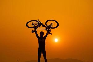 silhueta de um ciclista no pôr do sol na tailândia. foto