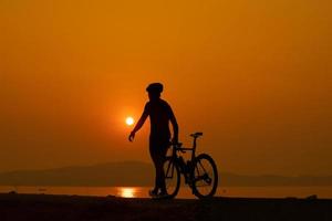 silhueta de um ciclista no pôr do sol na tailândia. foto