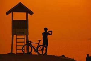 silhueta de um ciclista no pôr do sol na tailândia. foto