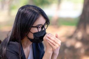 as mulheres de negócios asiáticas devem usar uma máscara facial para evitar a poluição por poeira e prevenir a infecção por vírus, durante o surto do vírus corona que precisa trabalhar em casa foto