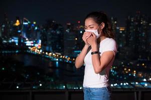 as mulheres asiáticas têm que usar uma máscara para cobrir o rosto para evitar a poluição da poeira foto