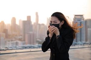 as mulheres asiáticas têm que usar uma máscara para cobrir o rosto para evitar a poluição da poeira foto