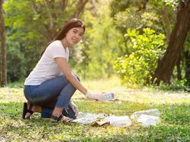 mulheres voluntárias coletam garrafas plásticas de água na área do parque, de pessoas que se recusam a jogar no lixo foto