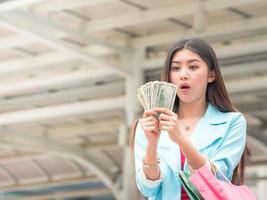 linda mulher asiática está animada depois de ganhar dinheiro para fazer compras foto