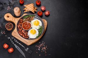 pequeno-almoço inglês completo com feijão, ovos fritos, salsichas assadas, tomate e cogumelos foto