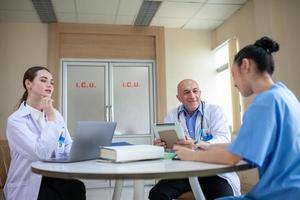 grupo de médicos consultando registros de pacientes, médico idoso e colega discutindo a terapia atual da doença no local de trabalho. foto