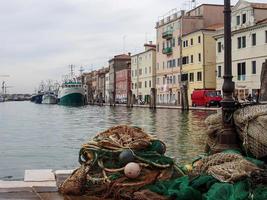 porto de chioggia com pequenos barcos perto de edifícios coloridos foto