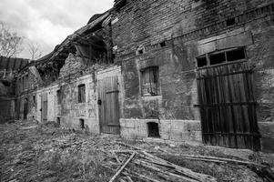 tiro em tons de cinza de casas abandonadas em ruínas foto