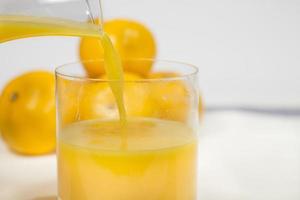 encher um copo de suco de laranja natural foto