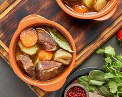 goulash com grandes pedaços de carne e legumes. carne borgonha. ensopado lento, cozinhando em duas panelas foto