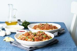 linguine de macarrão à bolonhesa com carne moída e tomate. jantar italiano para dois foto