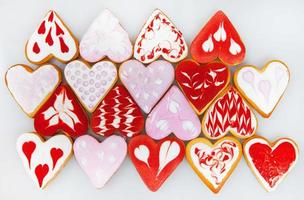 biscoitos de dia dos namorados. biscoitos em forma de coração para o dia dos namorados. biscoitos em forma de coração vermelho e rosa. padrão romântico sem costura com corações de biscoitos. foto