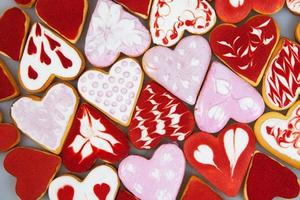biscoitos de dia dos namorados. biscoitos em forma de coração para o dia dos namorados. biscoitos em forma de coração vermelho e rosa. padrão romântico sem costura com corações de biscoitos. foto