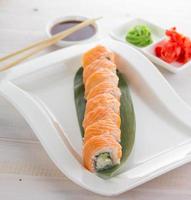 Filadélfia salmão sushi roll em um prato fundo de madeira foto