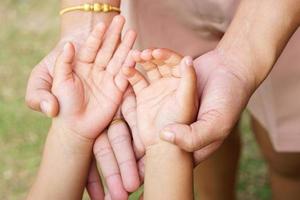 mão da mãe segurando a mão de uma menina no fundo bokeh. conceito de amor e família. foto
