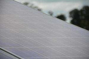 foco seletivo painéis solares no telhado de uma casa de cidade tropical no início da manhã foto