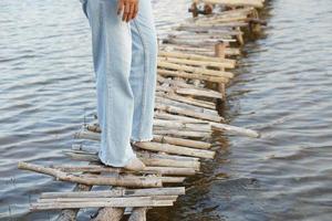 turista asiática caminha na ponte de bambu para chegar ao ponto de vista foto