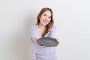 retrato linda mulher asiática segurando um prato vazio foto