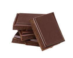 barras de chocolate escuras isoladas no fundo branco. pilha de pedaços de chocolate, closeup