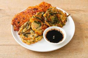 pajeon ou panqueca coreana e panqueca coreana kimchi ou kimchijeon em fundo branco foto