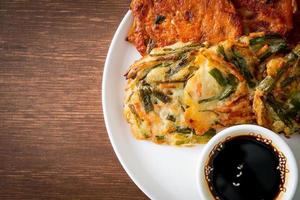 pajeon ou panqueca coreana e panqueca coreana kimchi ou kimchijeon em fundo branco foto