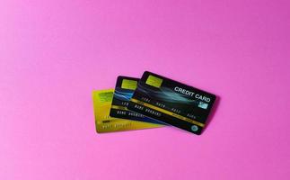cartão de crédito em fundo rosa foto