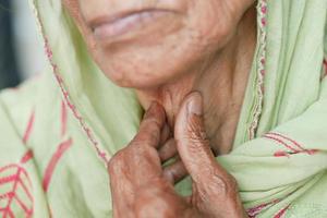mulheres idosas que sofrem de dor de garganta close-up foto