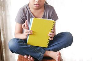 criança adolescente segurando muitos blocos de notas coloridos foto